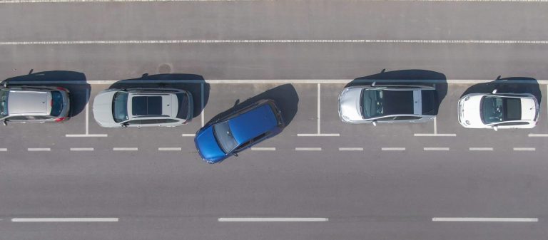 Drone,,Top,Down:,Flying,Above,A,Shiny,Blue,Car,Driving