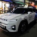 흐릿한 간판 앞 자율주행 SUV